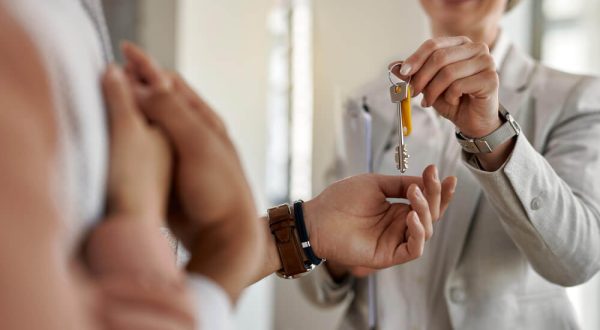 closeup-couple-receiving-keys-their-new-apartment-from-real-estate-agent
