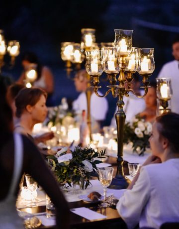 decorated-tables-with-floral-composition-old-fashioned-candlesticks-guests-celebration-evening
