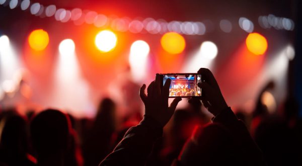 person-close-up-recording-video-with-smartphone-during-concert